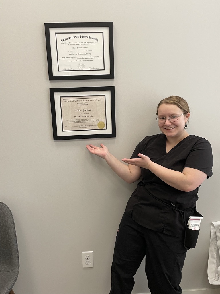 Allison Gerstner, LMT, with her massage therapy and NeuroMuscular Therapy certificates at Excelsior & Grand Chiropractic